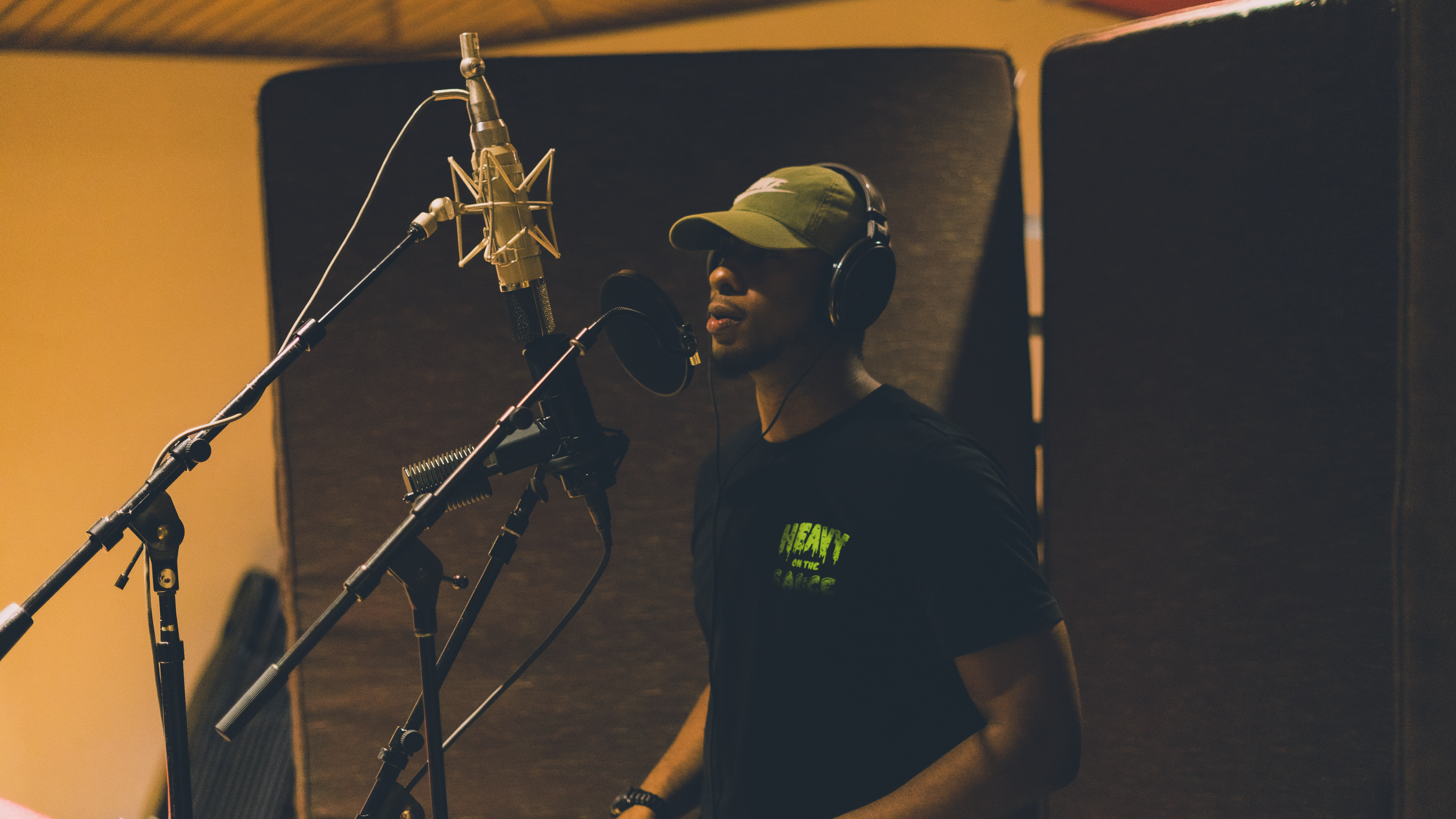 Gee Smiff stands in front of several microphones creating vocal tracks for his music sync placements.