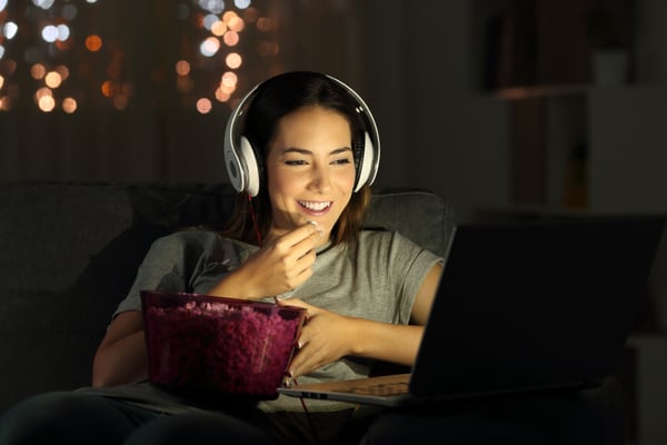 Young-woman-watches-a-movie-on-her-laptop-with-headphones-on