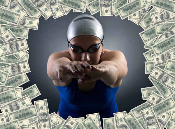 Female-swimmer-diving-through-circle-of-money