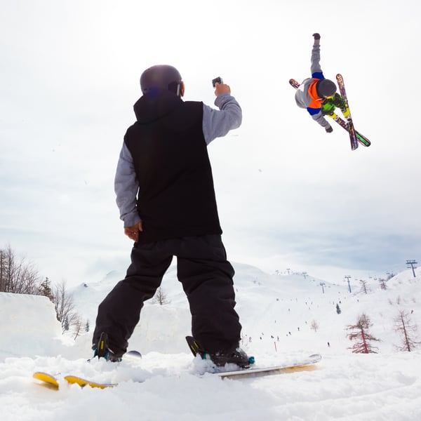 Man-recording-ski-jump-of-friend